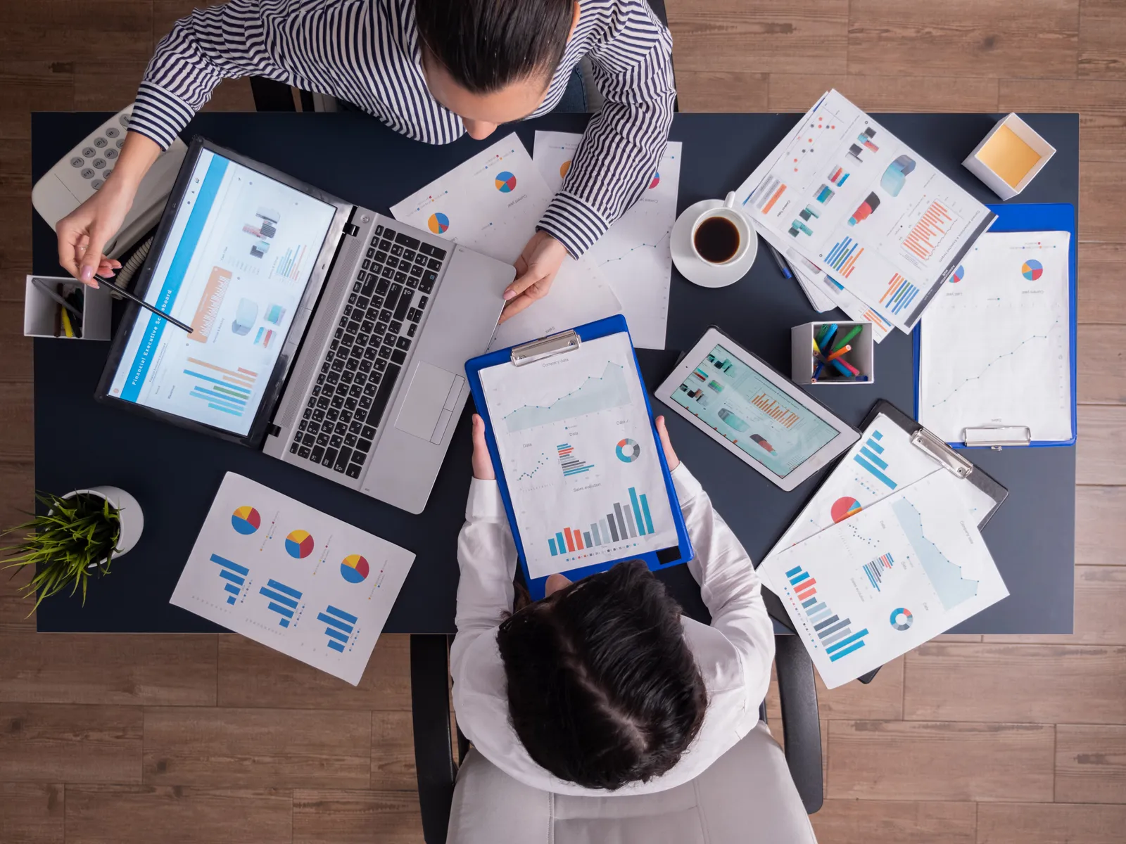 Equipe da Conexus analisando indicadores e relatórios em uma mesa de trabalho